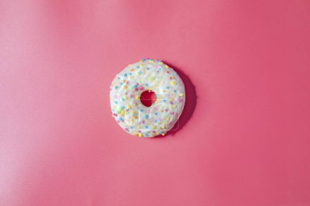 Foto de Donuts with icing on pastel pink background. Sweet donuts. top view assorted with various chocolate glazed and sprinkles, sugar sweets concept candy - Imagen libre de derechos