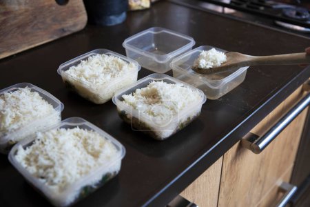Foto de Meal prep. Stack of home cooked rice and chicken dinners in containers ready to be frozen for later use as quick and easy ready meals. Food prepping for healthy dieting close up - Imagen libre de derechos