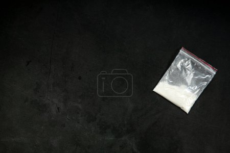 Photo for Cocaine powder lines, rolled banknote and drugs in plastic bag pocket on black glass surface background, top view. Drug addiction concept dark - Royalty Free Image