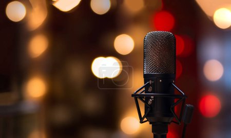 Studio microphone in neon lights. sound recording equipment on bokeh background. Podcast,recording music concept microphone copy space