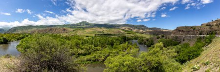 Photo for Mtkvari river valley panorama in Samtskhe Javakheti region in Southern Georgia with lush green vegetation and Lesser Caucasus mountains in the background. - Royalty Free Image
