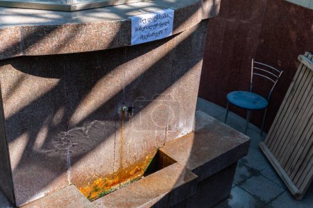 Foto de Borjomi, Georgia, 08.06.2021. Fuente de agua mineral termal y estación de servicio en el pabellón verde en Borjomi Central Park, ciudad balneario en Georgia, montañas del Cáucaso. - Imagen libre de derechos