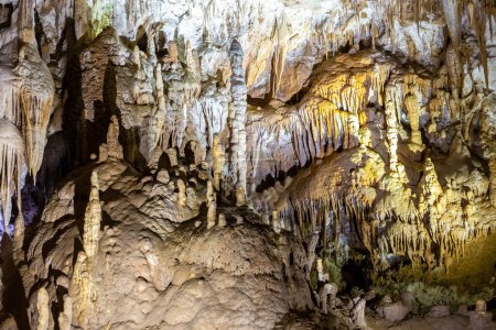 Téléchargez les photos : Monument naturel de la grotte Prometheus - la plus grande grotte de Géorgie avec des rideaux de pierre suspendus, stalactites et stalagmites, des formations rocheuses illuminées colorées. - en image libre de droit