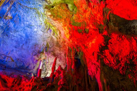 Téléchargez les photos : Monument naturel de la grotte Prometheus, Kutaisi, Géorgie, avec rideaux de pierre suspendus, stalactites et stalagmites, formations rocheuses illuminées colorées. - en image libre de droit