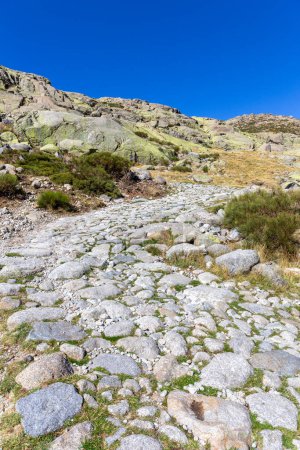 Photo for Stone hiking trail to the Laguna Grande de Gredos lake from the Plataforma de Gredos in Sierra de Gredos mountains, dry brown grass, autumn, Spain. - Royalty Free Image