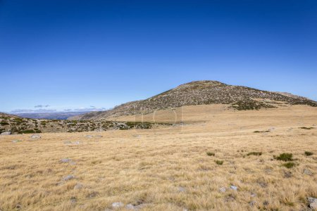 Photo for Sierra de Gredos mountain landscape in autumn, dry, barren vegetation and rocky hills, seen from the trail to the Laguna Grande de Gredos, Spain. - Royalty Free Image