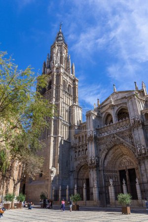 Photo for Toledo, Spain, 08.10.21. Toledo Cathedral (The Primatial Cathedral of Saint Mary of Toledo), Gothic church with great portals, statues, reliefs and bell tower seen from Plaza del Ayuntamiento. - Royalty Free Image