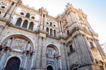 Photo for The Cathedral of Malaga front view from below with blue sky in the background.Medieval Roman Catholic church in renaissance style with baroque facade with arches and portals. Malaga, Andalusia,Spain. - Royalty Free Image