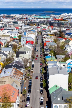 Foto de Reikiavik, Islandia, 14.05.22. Reykjavik paisaje urbano simétrico a lo largo de la calle Skolavordustigur, con edificios coloridos y Rainbow Street al final, visto desde la torre de la iglesia Hallgrimskirkja. - Imagen libre de derechos