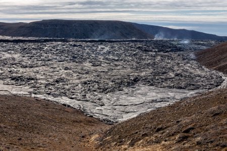 Foto de Campo de lava del volcán Fagradalsfjall con lava basáltica congelada creada después de la erupción y respiraderos humeantes, Islandia. - Imagen libre de derechos