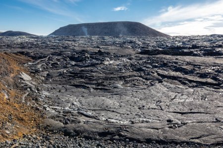 Champ de lave volcanique de Fagradalsfjall avec lave basaltique gelée créée après éruption, évents fumants et nouveau cône de cratère, Islande.
