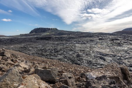 Paisaje del campo de lava del volcán Fagradalsfjall con lava basáltica congelada creada después de la erupción, respiraderos humeantes y nuevo cono del cráter, Islandia.