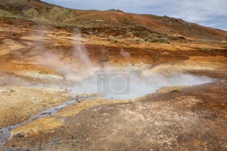 Seltun Geothermal Área en Krysuvik, paisaje con aguas termales humeantes y colores naranjas del suelo de azufre, Islandia.