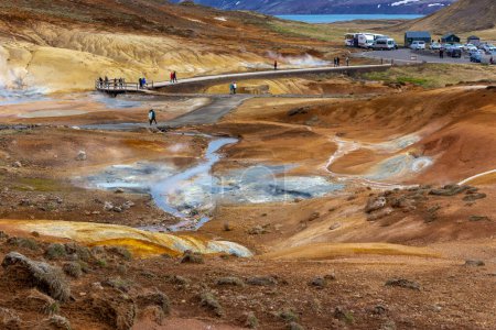 Téléchargez les photos : Krysuvik, Islande, 14.05.22. Seltun Geothermal Area à Krysuvik avec ses sources chaudes fumantes, ses collines de soufre jaune et orange, ses promenades à pied, son parking en arrière-plan. - en image libre de droit