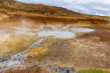 Seltun Geothermal Área en Krysuvik, paisaje con aguas termales humeantes y colores anaranjados de suelo sulfuroso, Islandia.