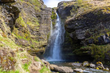 Gluggafoss (Merkjarfoss, Fensterfälle) Wasserfall in Südisland am Merkja-Fluss, Frühjahrsansicht der höheren Tropfen, moosbewachsene Felsen, keine Menschen.