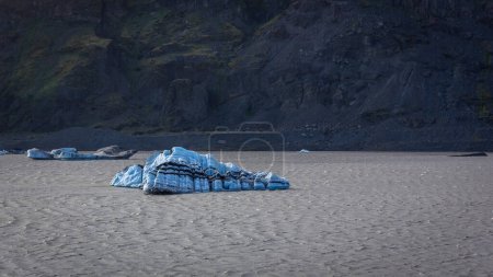 Blauer Eisberg schwimmt in der Solheimajokull-Gletscherlagune, Teil des Myrdalsjokull-Gletschers, Island.