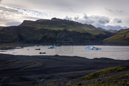Solheimajokull, partie du glacier Myrdalsjokull, lagune de glacier avec icebergs bleus flottants et paysage de montagne brut, Islande.