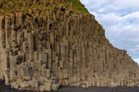 Basalt hexagonal columns rock formation on Reynisfjara Black sand beach, Iceland.