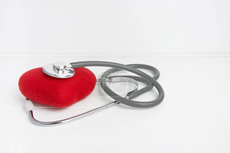 Photo for Gray stethoscope and red heart isolated on wooden white background - Royalty Free Image