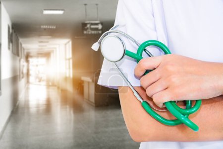 Foto de Doctor in grayscale of hospital interior with white uniform and green stethoscope and hands and free space for you - Imagen libre de derechos