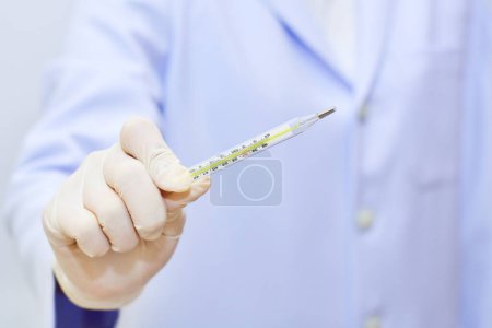 Photo for Doctor with hand holding thermometer - Royalty Free Image