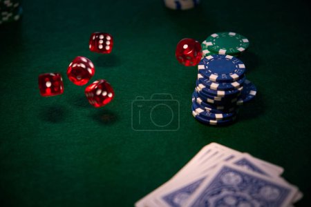 Photo for A few red dice chips cards on green cloth for poker - Royalty Free Image