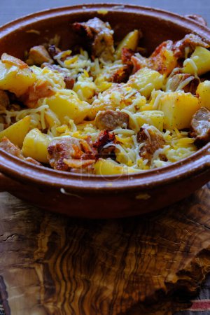 Photo for Oven-baked potatoes with meat and cheese in a clay plate - Royalty Free Image