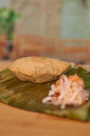 Photo for Central American El Salvador culinary delight called Pastelito mader of meat in a restaurant on a wooden table served with curtido. - Royalty Free Image