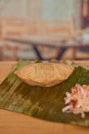 Photo for Central American El Salvador culinary delight called Pastelito mader of meat in a restaurant on a wooden table served with curtido. - Royalty Free Image