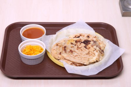 Photo for Close-up photo of pupusas with curtido and sauce, served on a traditional plastic plate in a fast food tray. - Royalty Free Image