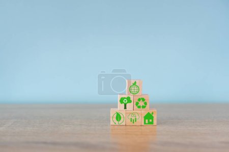 Carbon neutral concept. Net zero greenhouse gas emissions target. Climate neutral long term strategy. Stacking wooden cubes with green net zero and save world icon on grey background.