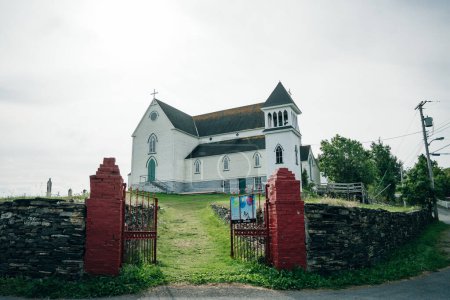 Foto de Iglesia de San Jorge, Brigus, Terranova. Iglesia en la colina enmarcada por los postes de la puerta roja - sep 2022. Foto de alta calidad - Imagen libre de derechos