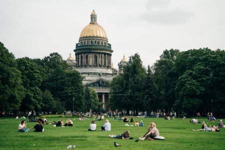 Foto de Gente en la hierba frente a la catedral de St. Isaac. San Petersburgo, Rusia - agosto 2022. Foto de alta calidad - Imagen libre de derechos