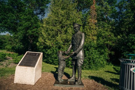 Foto de Winnipeg, Manitoba, Canadá - 2022: Estatua del Teniente Harry Colebourn y Winnie the bear, inspiración para el Winnie the Pooh. Estatua de Winnie el oso en el zoológico de Assiniboine Park - Imagen libre de derechos