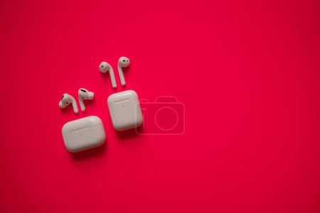 White headphones with wireless charging case. New Airpods 2019-2020 on black background. Female and male headphones. Copy Space. Phone. canada - may, 2022