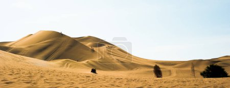 Young people enjoy the desert in the dunes of Ica. January 2022 Ica Peru. High quality photo