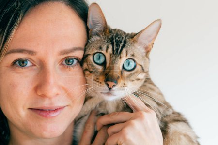 Porträt eines Mädchens und ihrer bengalen Katze. Blaue Augen. Hochwertiges Foto