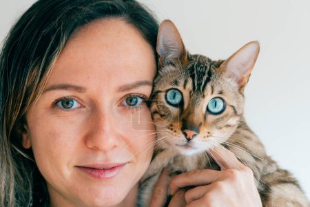 portrait of a girl and her bengal cat. Blue eyes. High quality photo