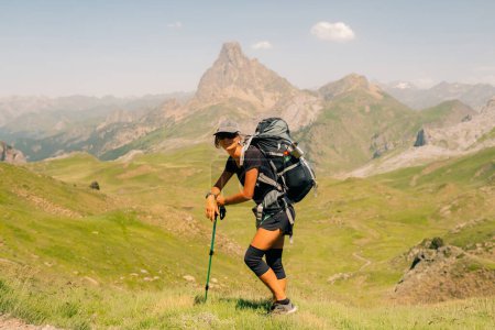 hiker and view of Pic d'Ossau in the French Pyrenees National Park. Ossau Valley, Pyrenees National Park, Pyrenees, France. High quality photo