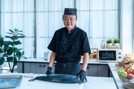 Photo for Japanese chef cleaning salmon. A worker cutting salmon on a board. - Royalty Free Image