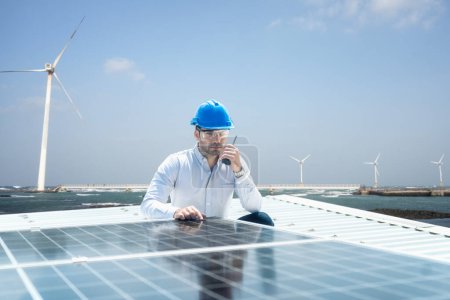 Foto de Energía solar y eólica renovable. Foreman está usando una radio en el área del panel solar y energía renovable. - Imagen libre de derechos