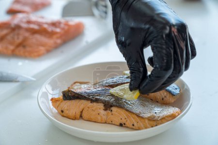 Téléchargez les photos : Poisson de mer frit. Préparation sur feu ouvert. Steaks de saumon servis avec des quartiers de citron. - en image libre de droit