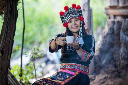 Foto de Tribus de la colina y café caliente. La mano de la mujer sosteniendo taza de café caliente. - Imagen libre de derechos