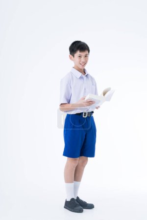 Téléchargez les photos : Je retourne à l'école. Des étudiants thaïlandais. Le garçon debout et lisant un livre. - en image libre de droit