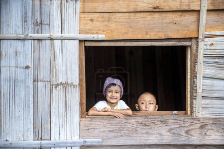 Téléchargez les photos : Des touristes portant des vêtements de tribu des collines. Un Akha sur la fenêtre. Touristes portant des vêtements de tribu Hmong Hill. - en image libre de droit