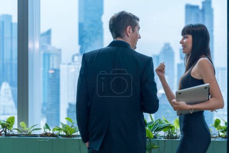 Téléchargez les photos : Homme d'affaires utilisant un ordinateur portable et un téléphone portable sur un grand immeuble dans l'immeuble de bureaux. - en image libre de droit