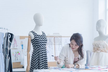 Foto de Mujer diseñadora de moda trabajando en el estudio de diseños. La mujer está trabajando en el taller. - Imagen libre de derechos