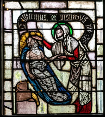 Foto de Vidriera ventana de la iglesia con escenas de misericordia y la vida de los santos - Imagen libre de derechos