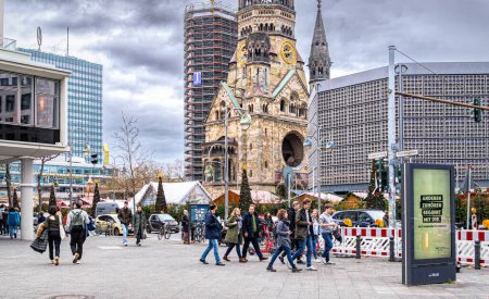 Photo for Berlin, Germany - December 31, 2022: Colourful holiday Christmas market in Berlin and a Gedchtniskirche, Kaiser Wilhelm Memorial Church. People celebrating the New Year Eve - Royalty Free Image